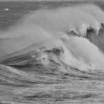 Vagues déchaînées sous une tempête, illustrant la violence et l’instabilité d’une crise autistique, où les émotions se heurtent comme des vagues.